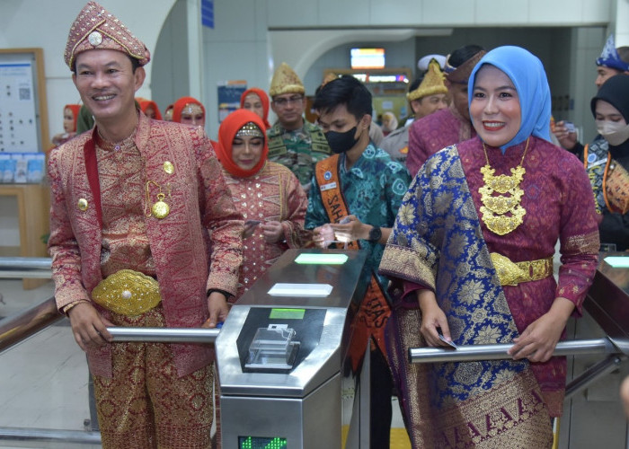 Pakai Baju Adat Palembang, Walikota Palembang Harnojoyo dan Wawako Fitrianti Agustinda Naik LRT..